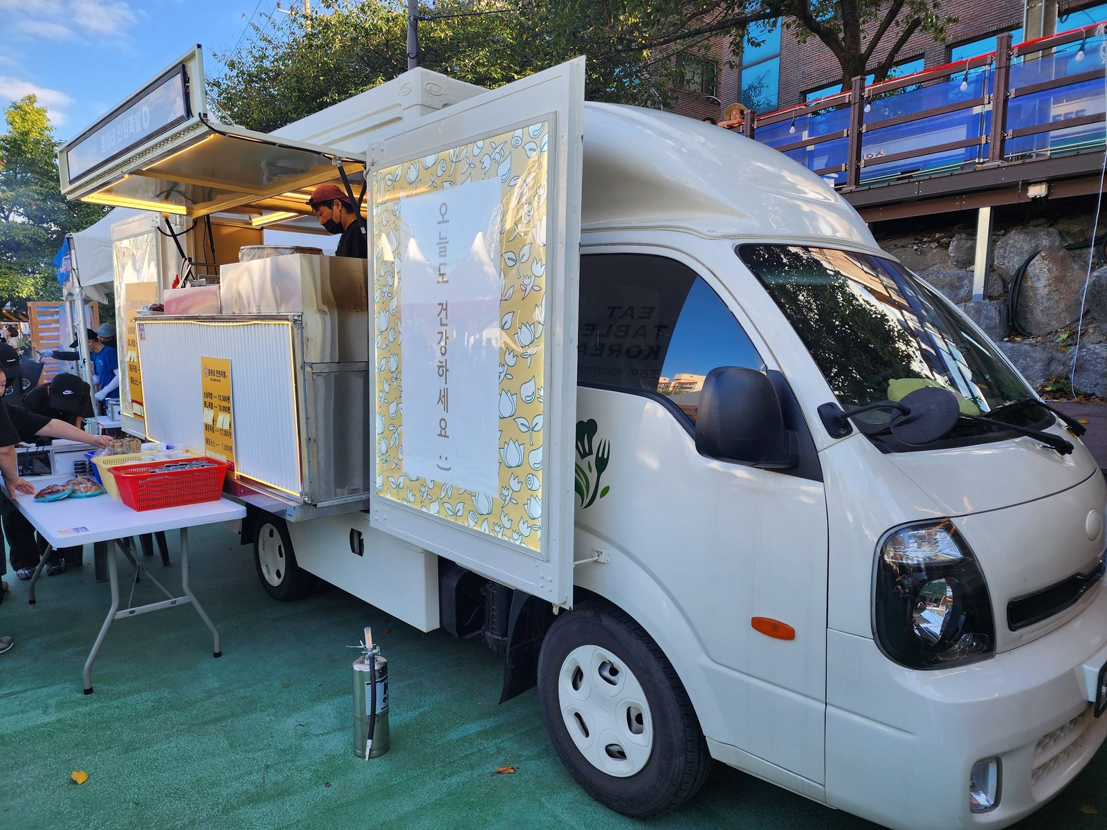 축제장에서 판매창과 도어를 활짝 열고 영업 중인 푸드트럭