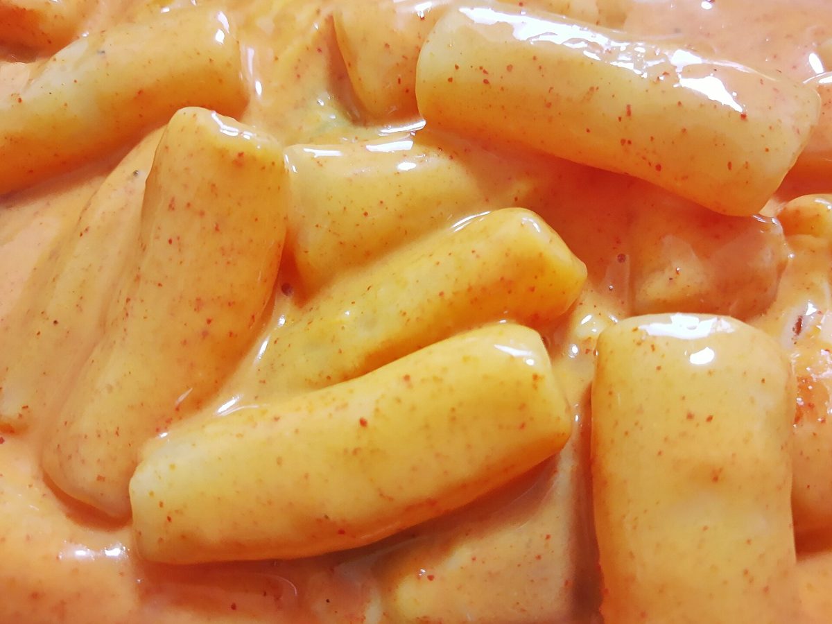 분홍빛 로제 소스에 버무린 떡볶이 떡을 가까이서 찍은 사진